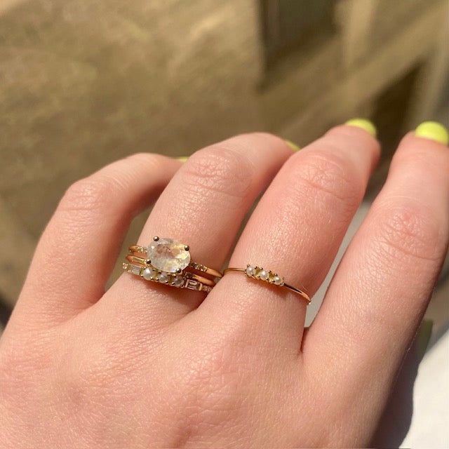 Pearl and Moonstone gold rings displayed on hand