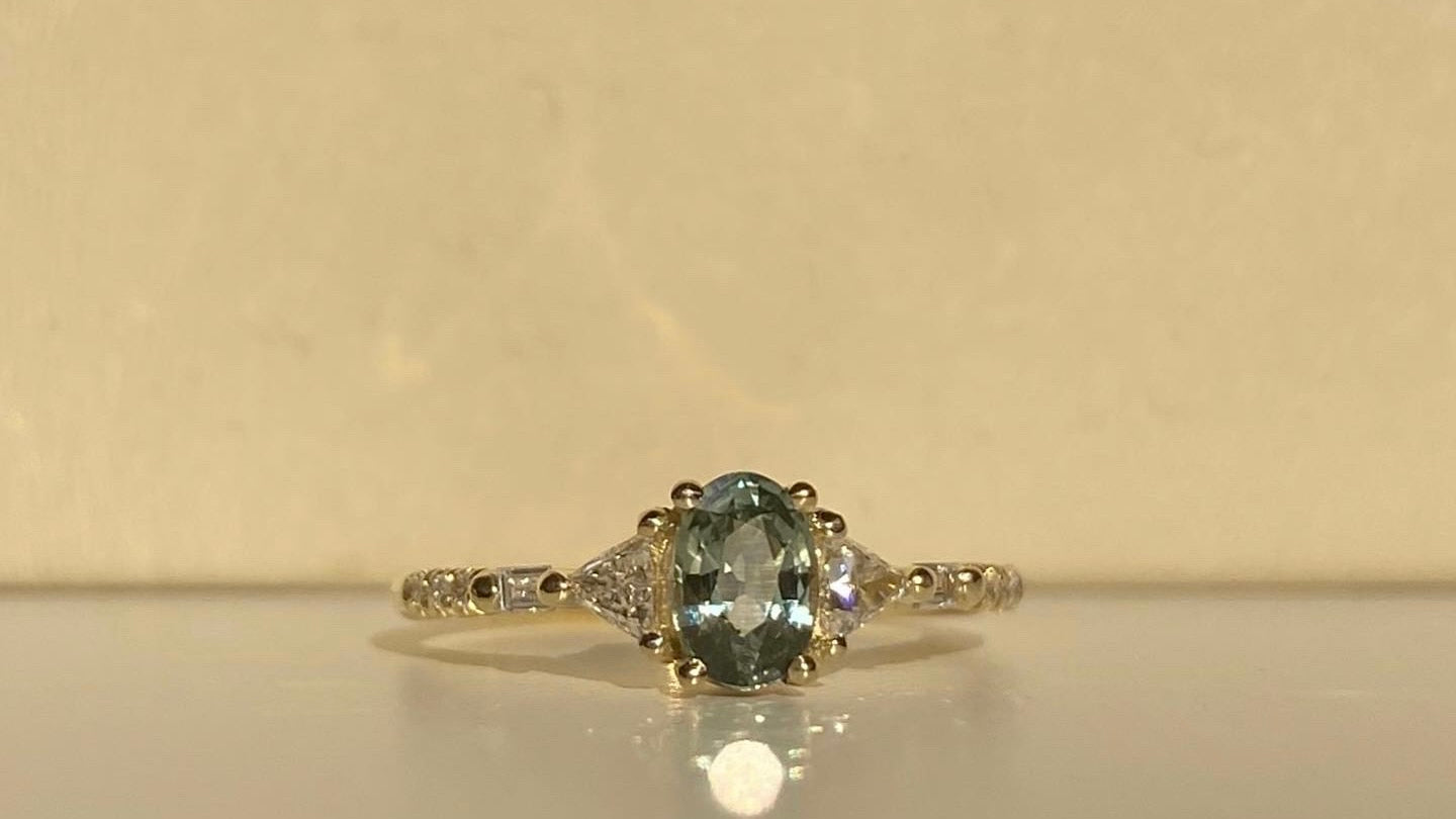 14k yellow gold custom ring with oval cut blue sapphire center stones with white side diamonds 