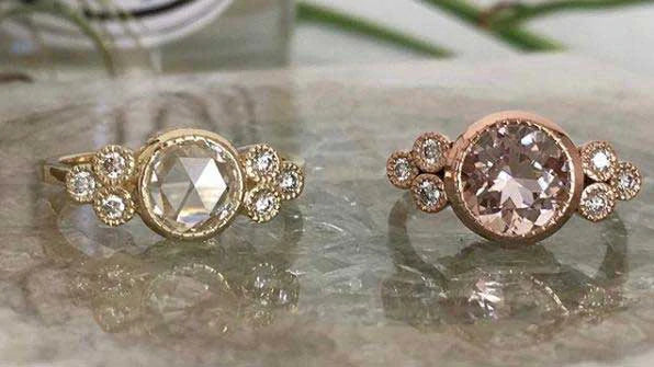 14k yellow gold custom engagement ring with round cut white diamond center stone and 6 white diamond side stones with milgrain detail and 14k rose gold custom engagement ring with white diamond center stone and 6 white diamond side stones and milgrain