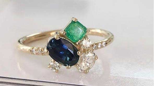 14k yellow gold custom ring with blue sapphire oval cut and square cut emerald and white diamonds and pave white diamond equilibrium