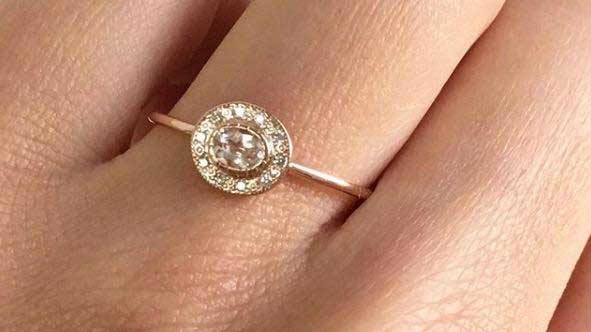 14k yellow gold custom ring with white diamond center stone surrounded by white diamonds in circle on hand
