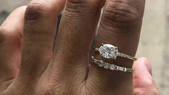 14k yellow gold custom engagement ring with pear cut white diamond center stone and equilibrium pave white diamonds and three white diamond 14k yellow gold band with baguette white diamonds