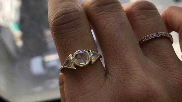 14k yellow gold custom ring with round center stone and white diamond side stones and 14k yellow gold band
