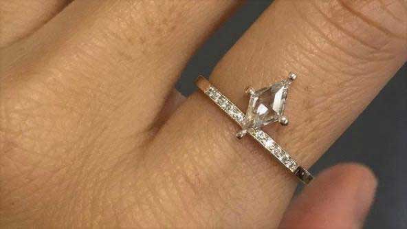 14k yellow gold custom ring with diamond cut white diamond with band with surrounded by pave white diamonds on hand