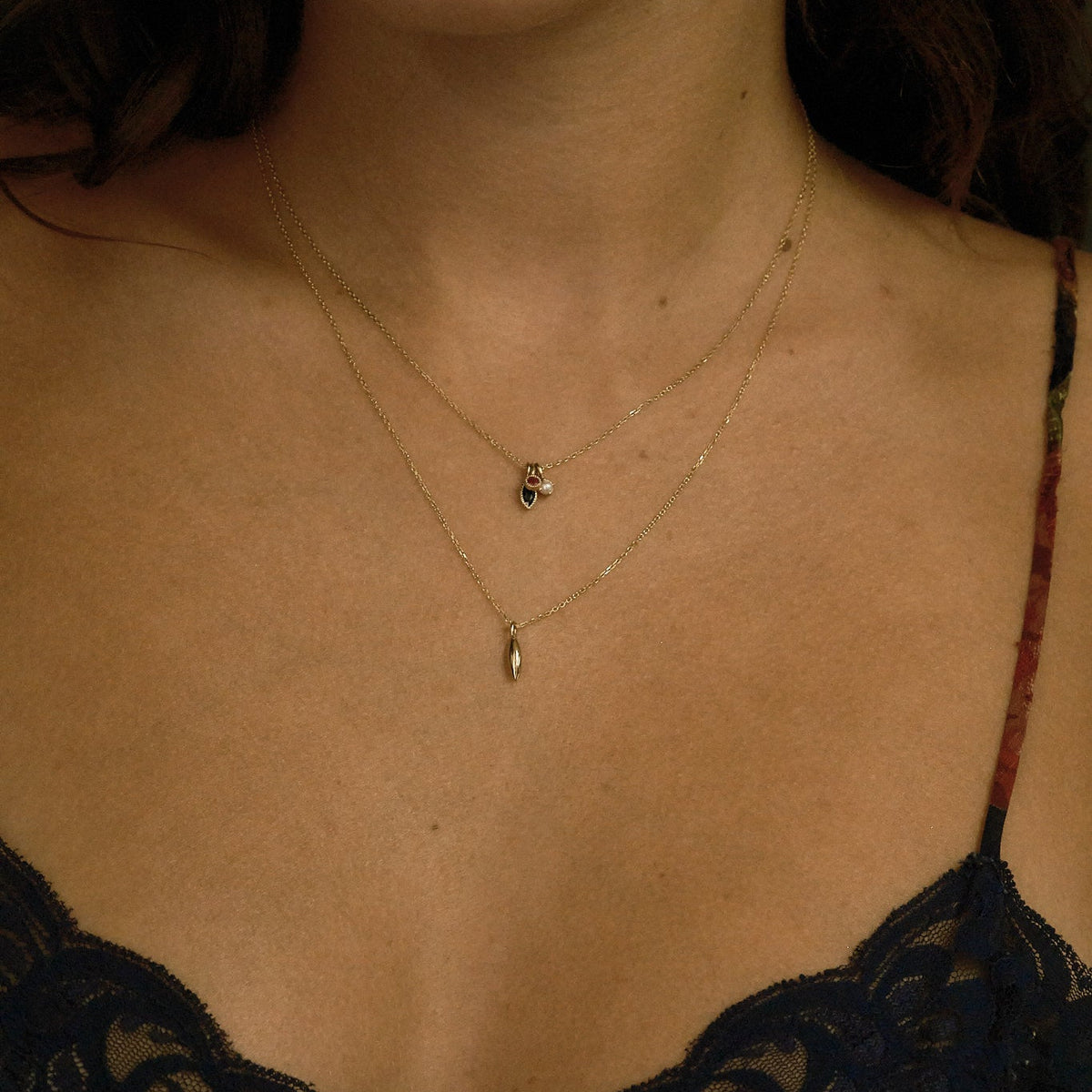 Close-up of a woman wearing a delicate necklace with a small pendant.