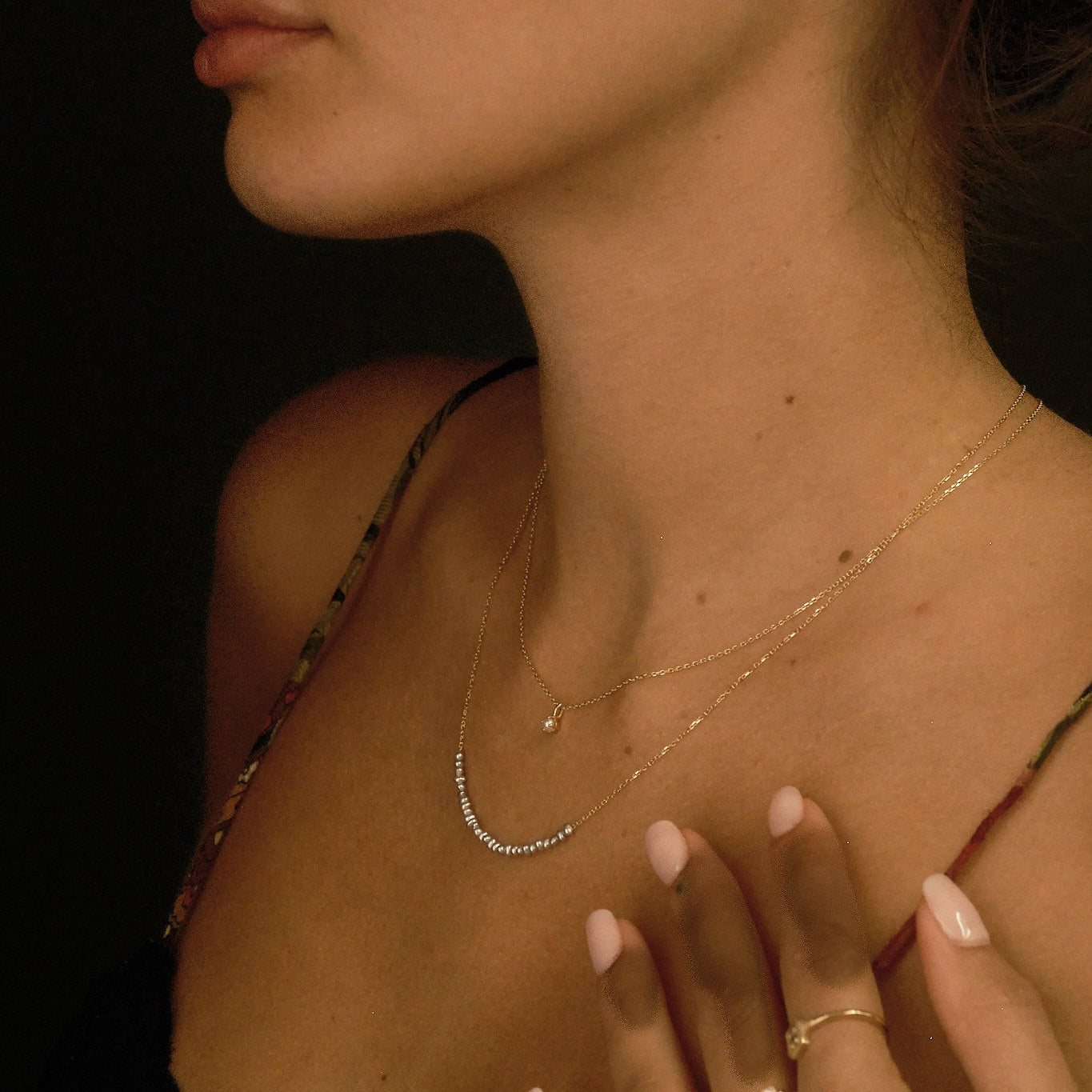 Close-up of a woman's profile with jewelry on a dark background