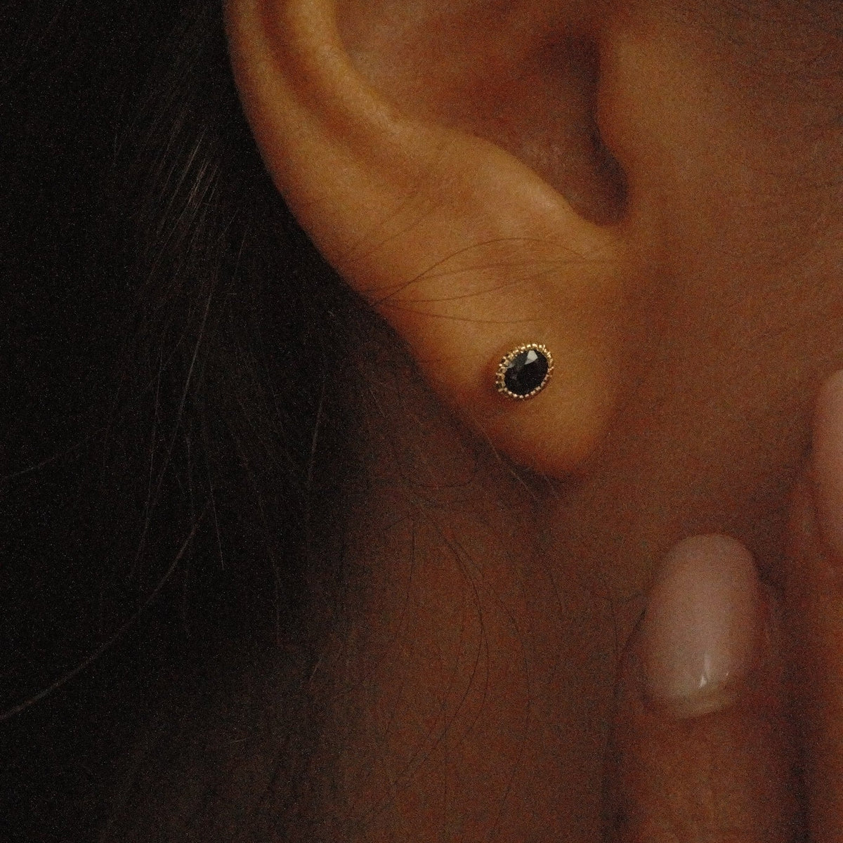 Close-up of an ear with a gold earring