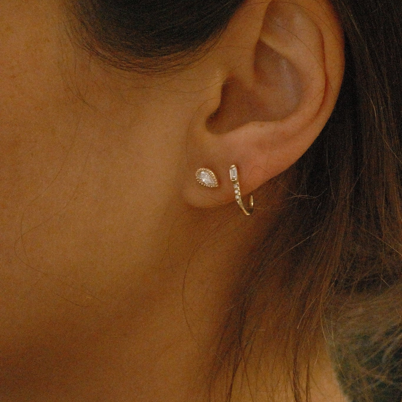 Close-up of an ear wearing a delicate earring with a blurred background