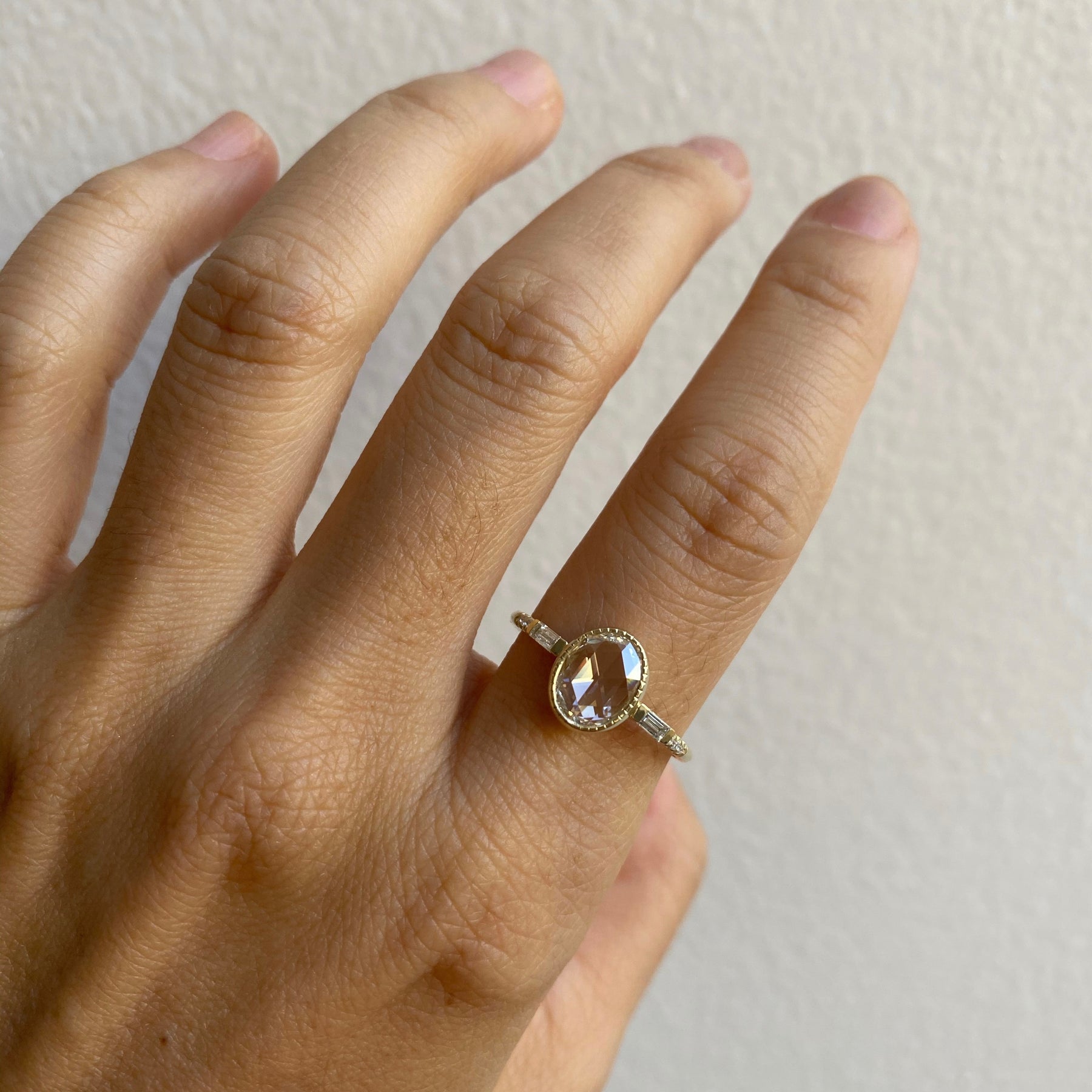 14k yellow gold custom ring with round cut white diamond center stone and pave white diamond equilibrium style on hand