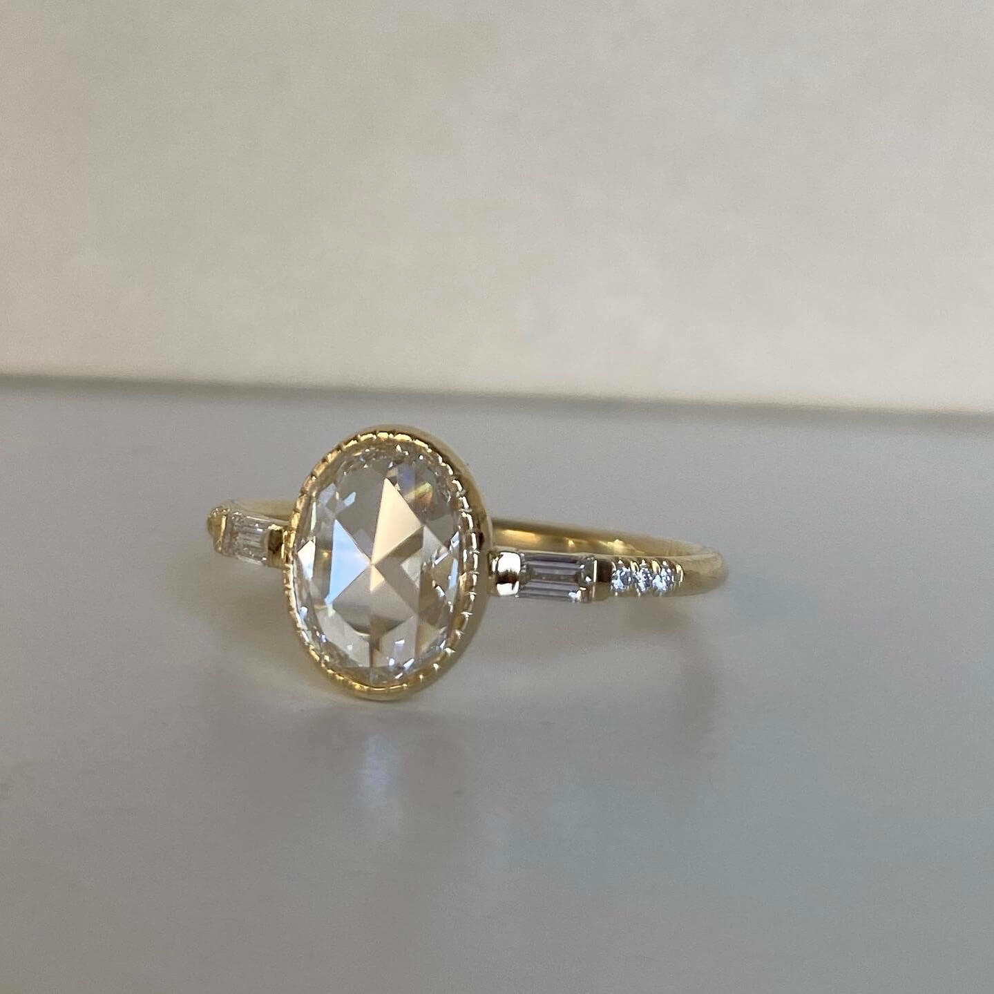 14k yellow gold custom engagement ring with oval white diamond center stone with white diamond baguettes
