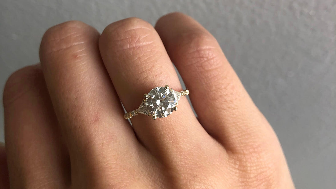 14k yellow gold custom engagement ring with round cut white diamond center stone with pave white diamonds on hand