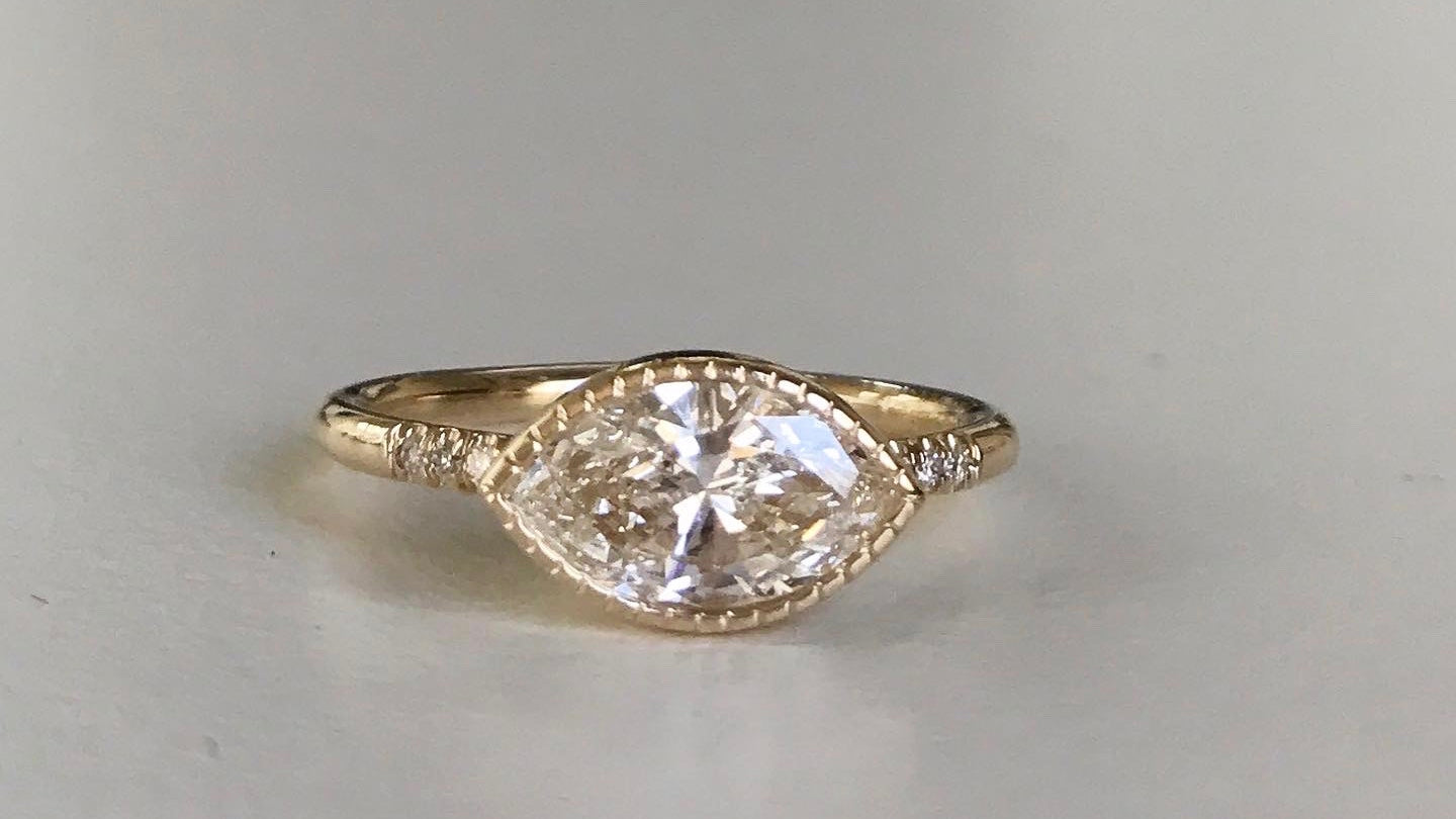 14k yellow gold custom ring with marquise white diamond center stone with milgrain detail and equilibrium white diamonds
