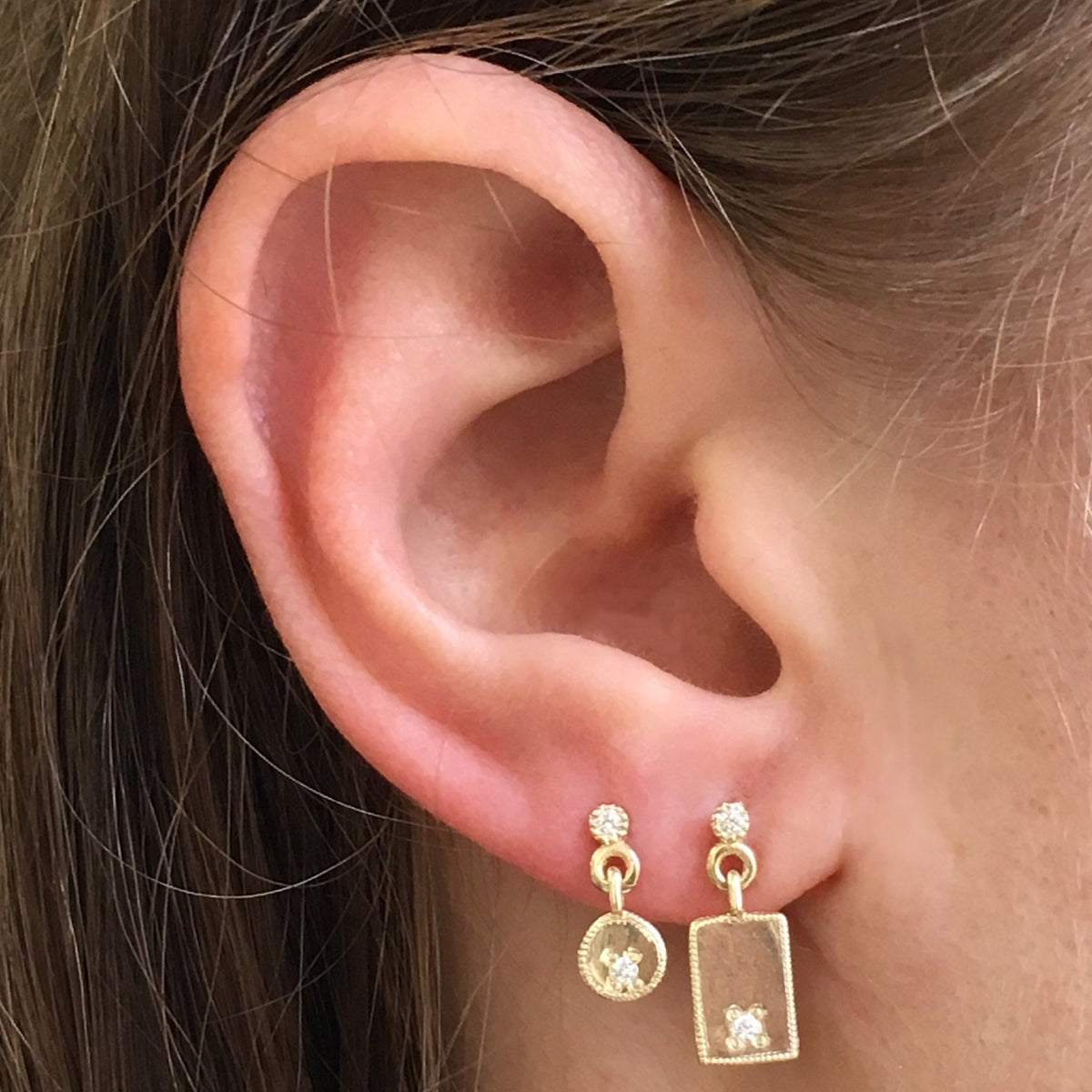 detail, Gold circle drop stud with two 1.5 mm diamonds paired on ear with gold circle stud