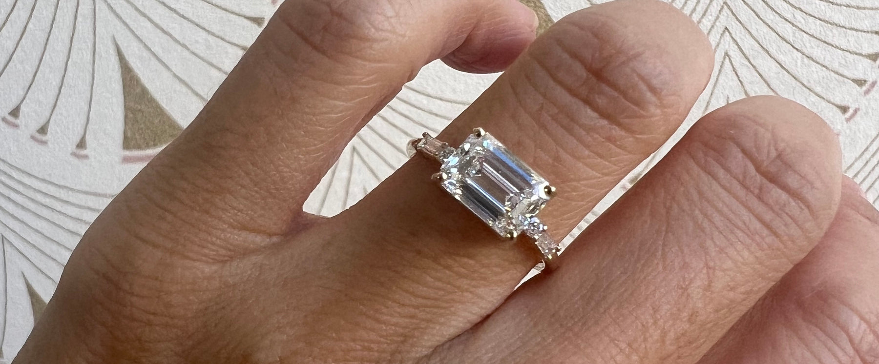 14k white gold custom engagement ring with emerald cut white diamond center stone, baguette diamonds and pave diamonds