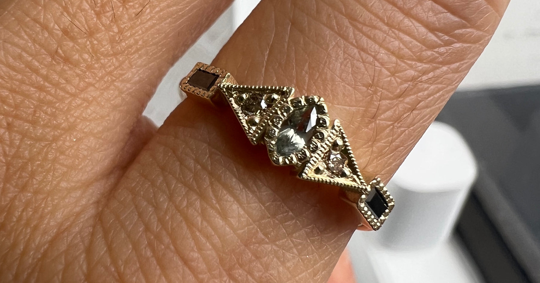 14k yellow gold custom engagement ring with marquise green sapphire center stone, champagne diamonds and baguette black diamonds