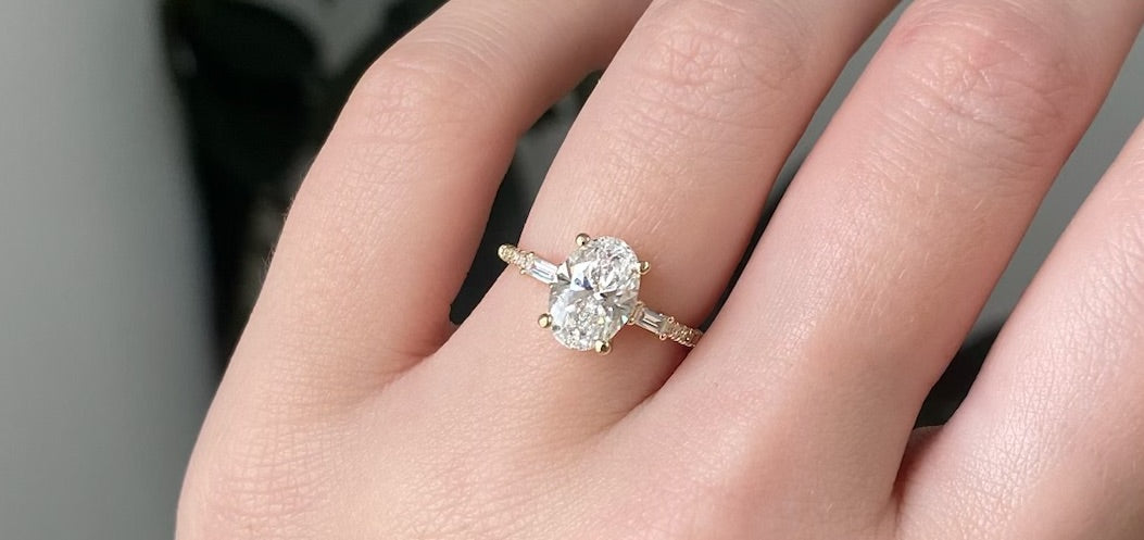 14k yellow gold custom engagement ring with oval white diamond center stone with white diamond baguettes