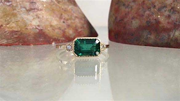 14k yellow gold custom ring with princess cut emerald center stone with milgrain detail and white diamond side stones (Lexie Style) 