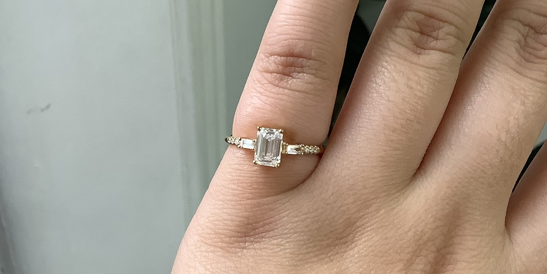 14k yellow gold custom engagement ring with emerald cut white diamond center stone