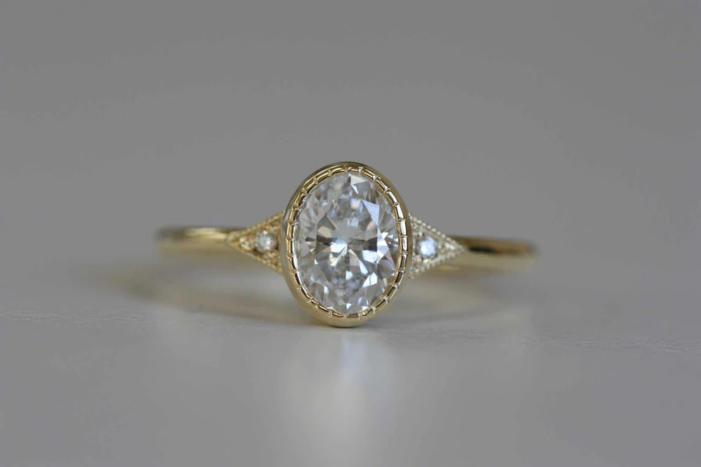 14k yellow gold custom engagement ring with white diamond center stone and white diamond side stones and milgrain detail