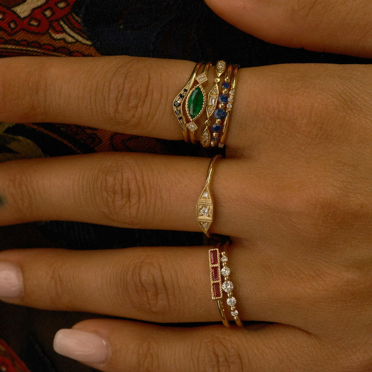 Close-up of a hand wearing multiple rings with intricate designs.
