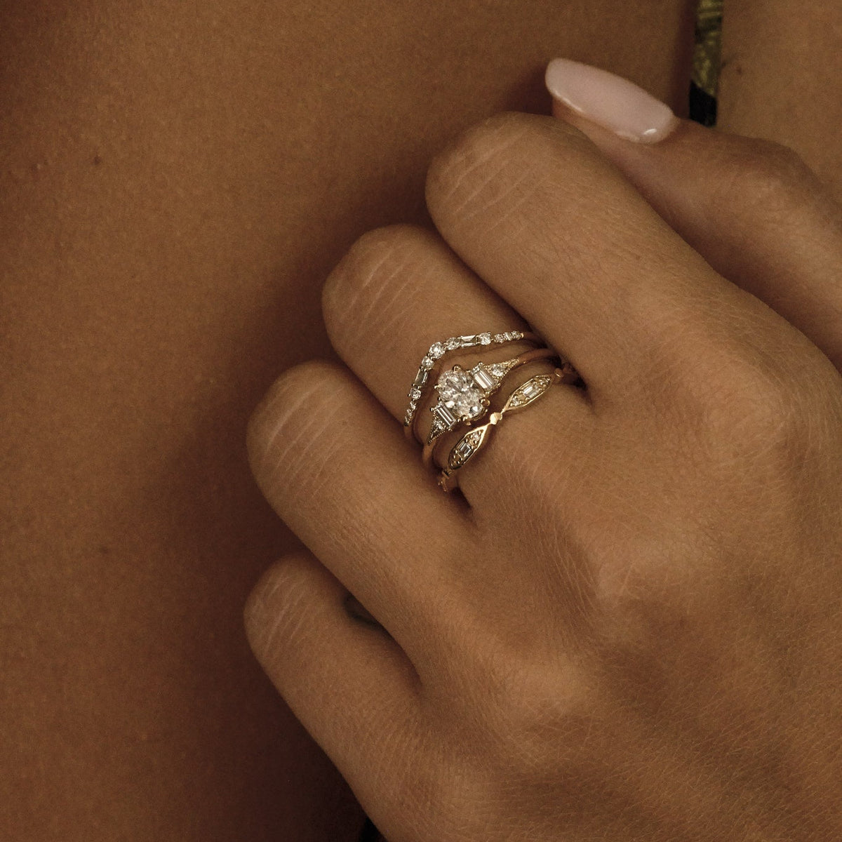 Close-up of a hand with a ring on a person's chest.