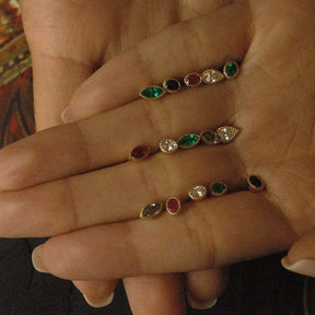 Close up of hand holding gemstone earrings