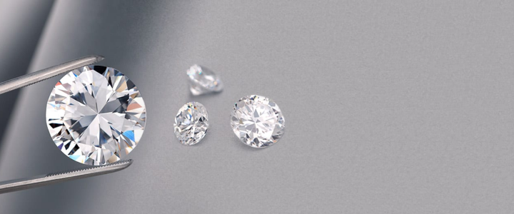 Various sizes cut diamonds on a grey background