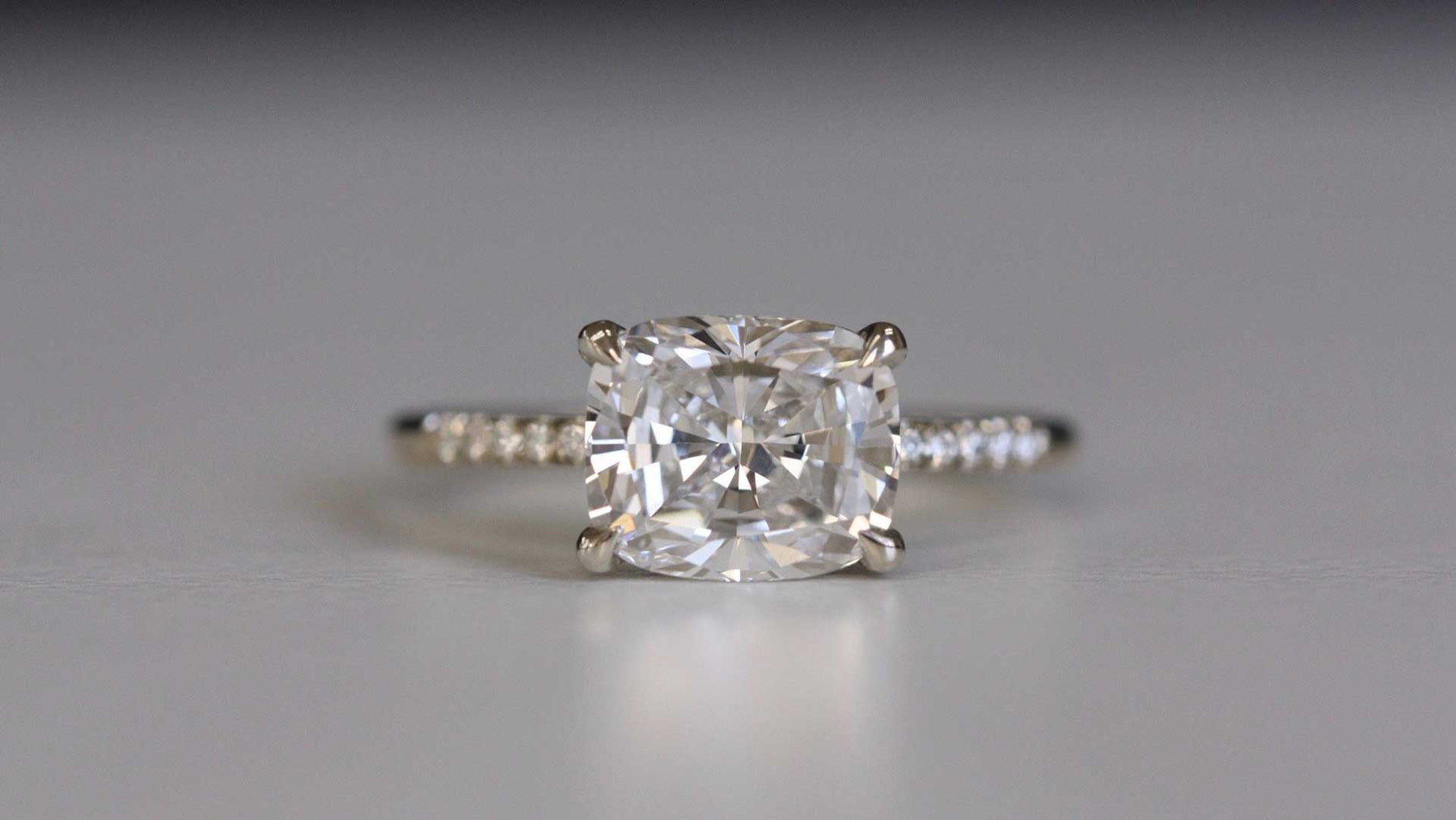 14k yellow gold custom engagement ring with princess cut white diamond center stone and white diamond equilibrium pave stones