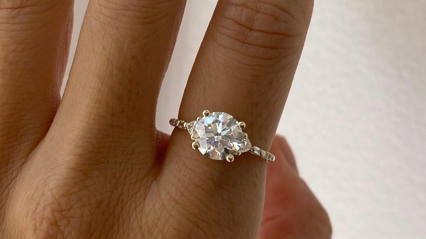 14k yellow gold custom engagement ring with marquise cut white diamond center stone with equilibrium style white diamond pave stones
