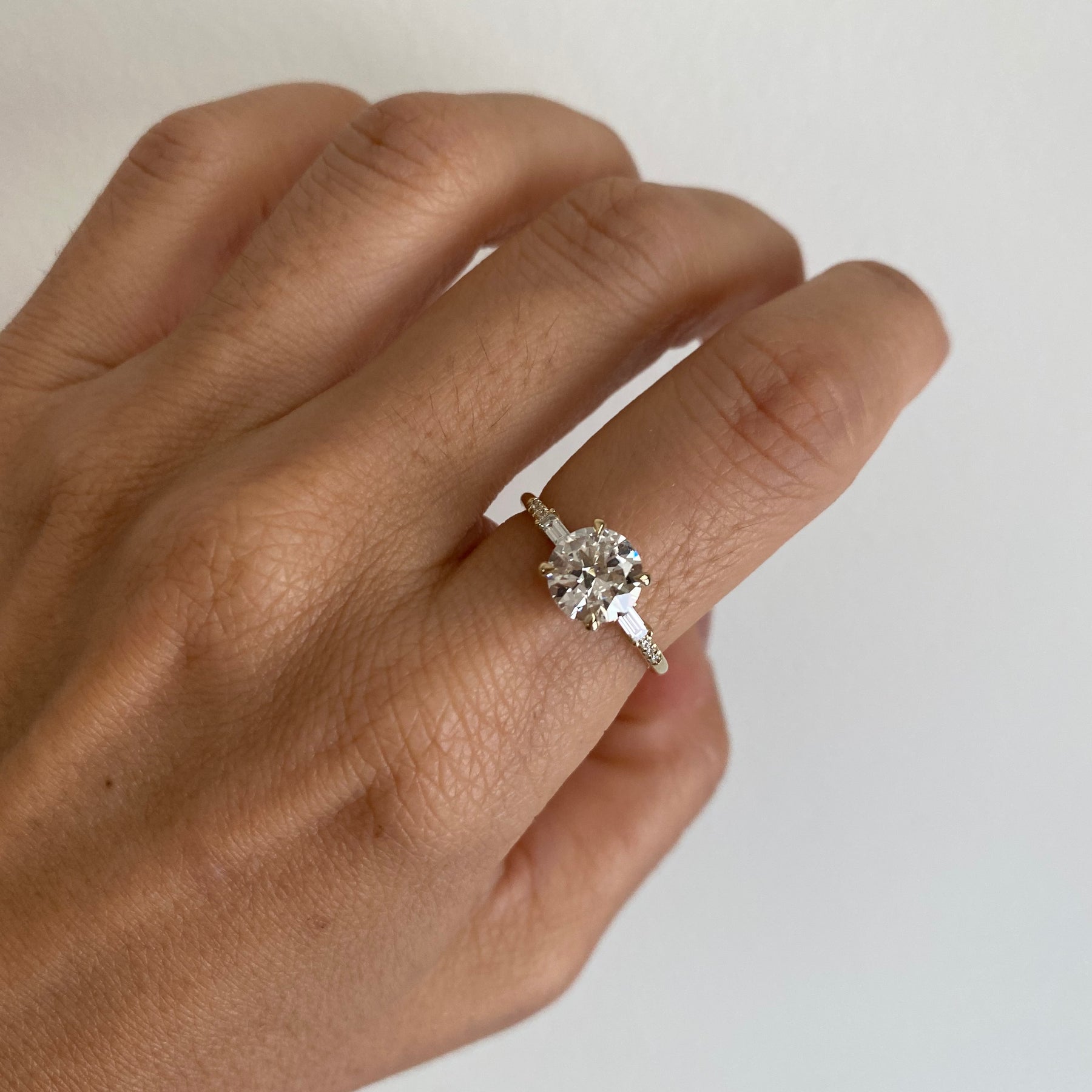 14k yellow gold custom engagement ring with brilliant cut white diamond center stone on hand