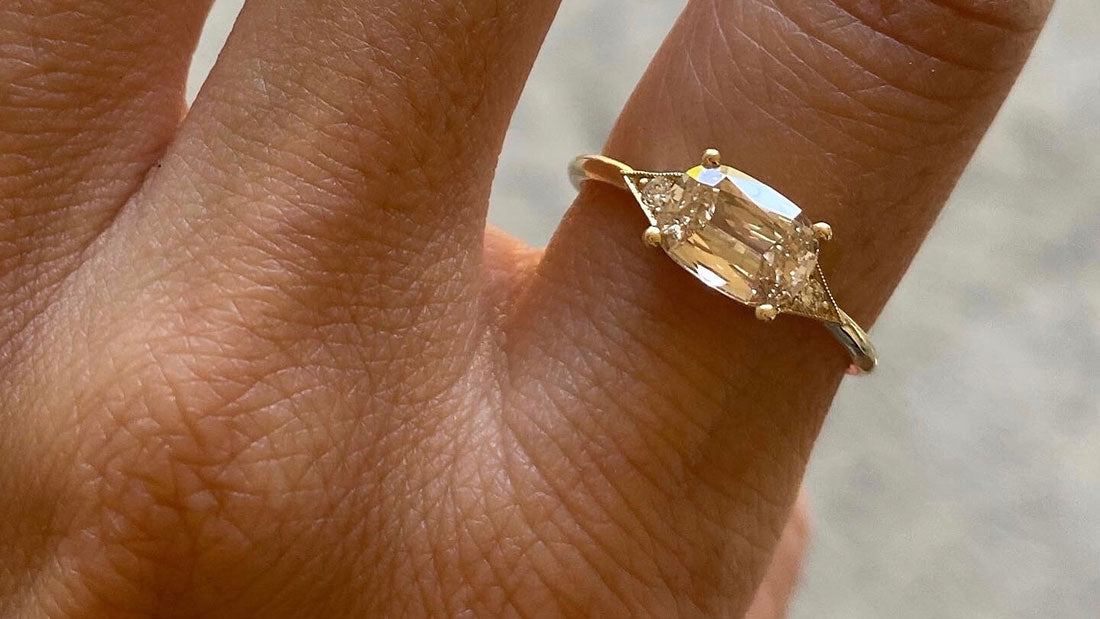 Yellow gold ring with diamond on finger