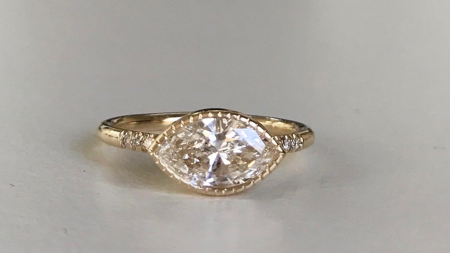14k yellow gold custom ring with marquise white diamond center stone with milgrain detail and equilibrium white diamonds 
